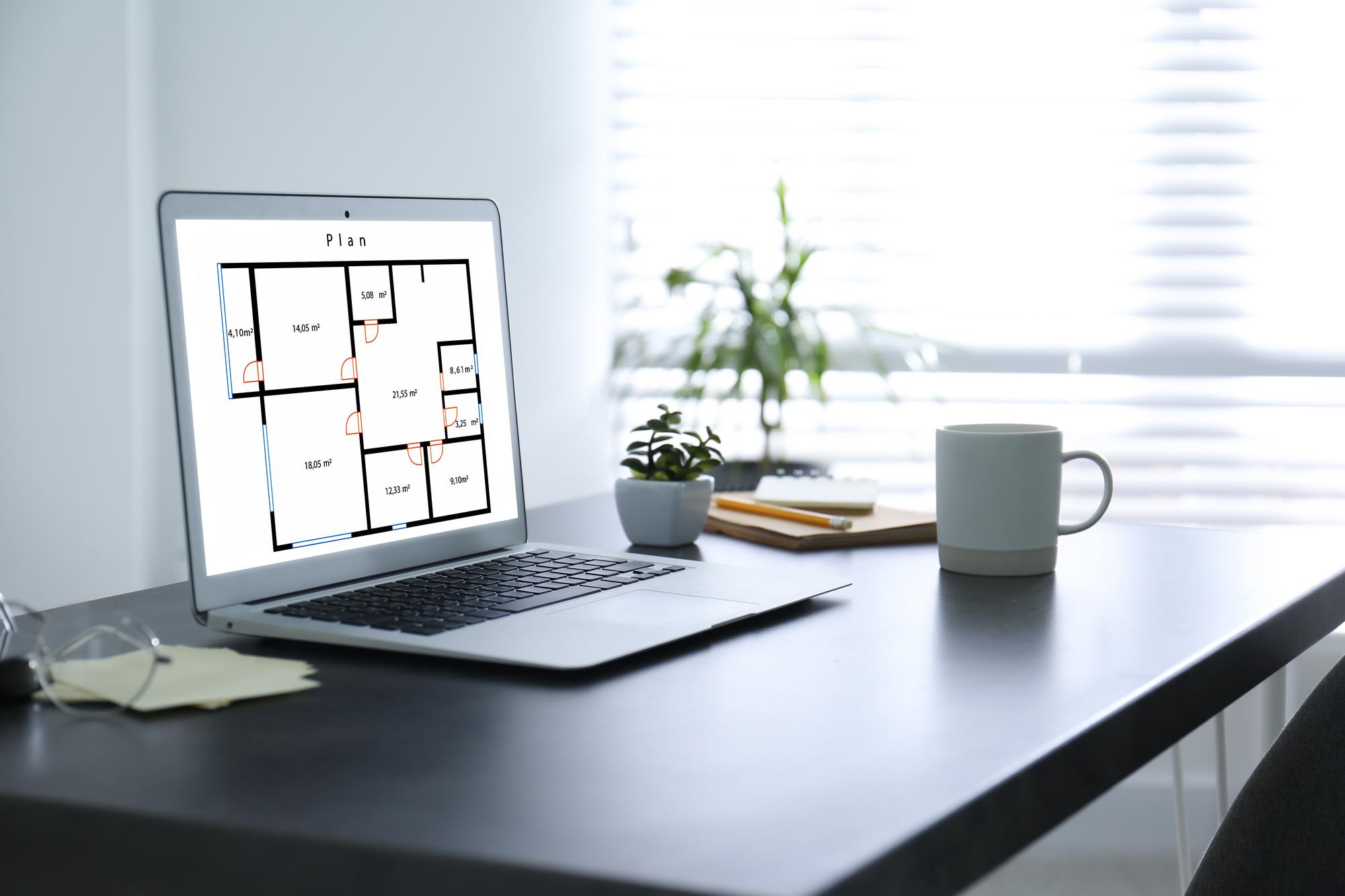 birou modern al agentiei cu planuri si laptop